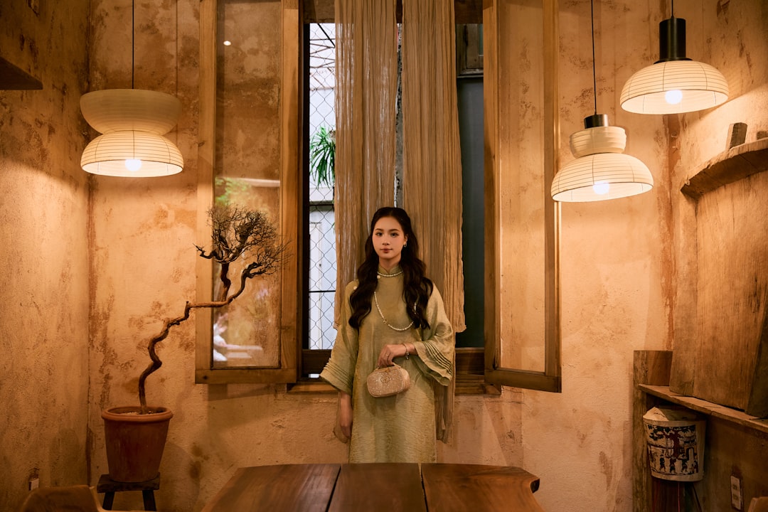 Young woman in vintage dress standing indoors.