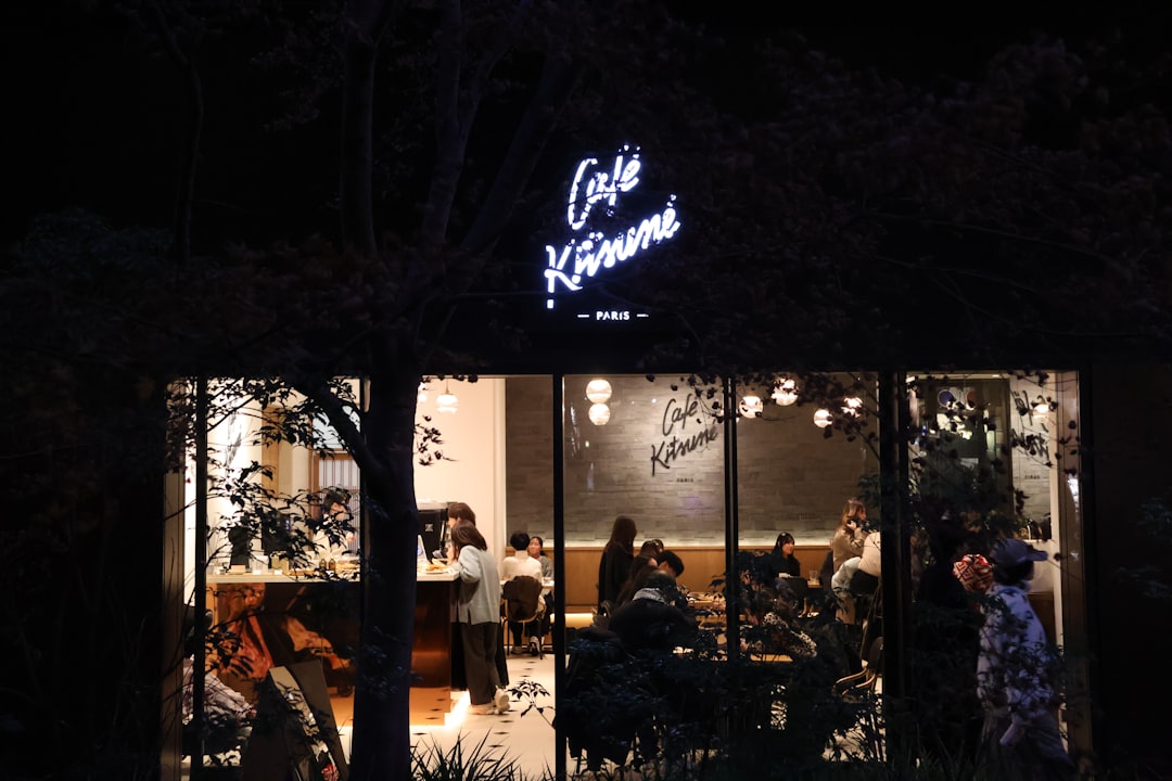 A group of people sitting outside of a restaurant at night