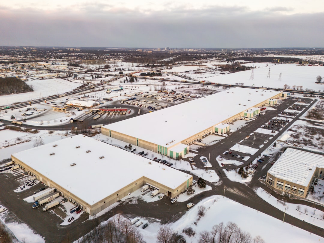Aerial view of industrial warehouses covered in snow.