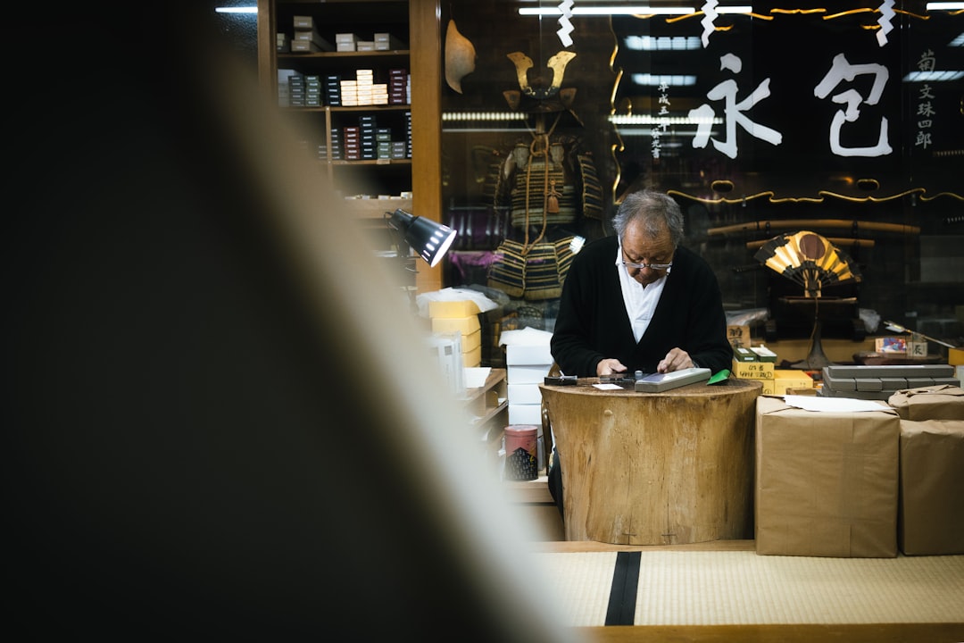 Elderly man working at a counter in a shop